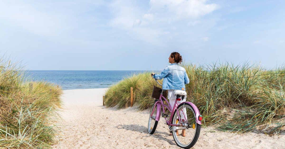 woman with bike on beach