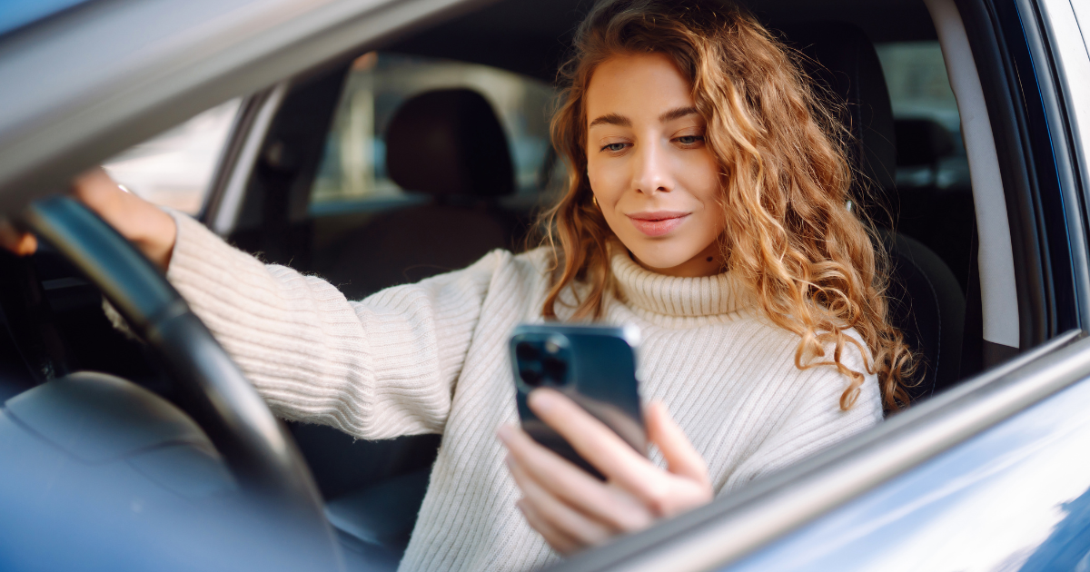 woman in parking car looking at phone