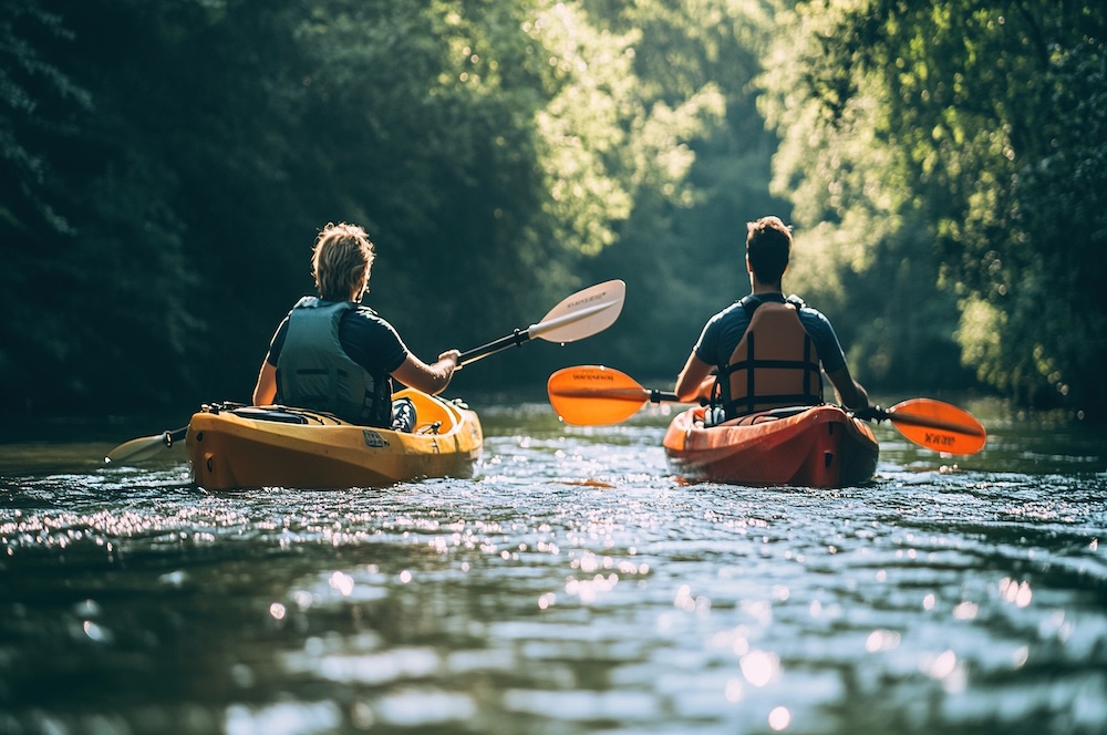 2 people kayaking through a creek