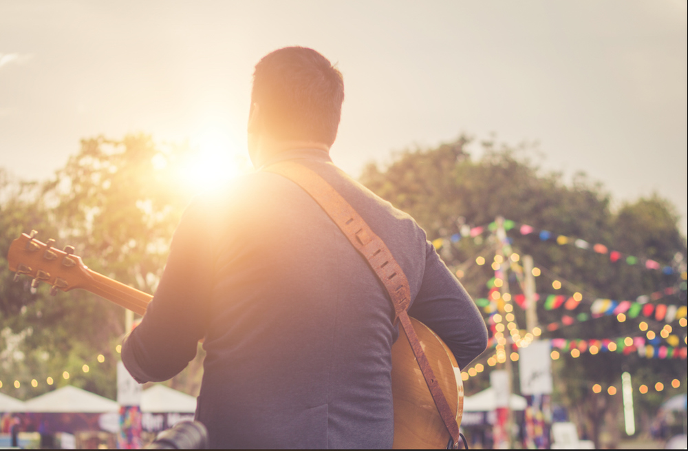guy playing music on stage at a street festival