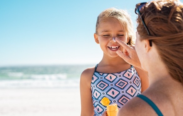 mother applying sunscreen to daughter | Williamson Realty