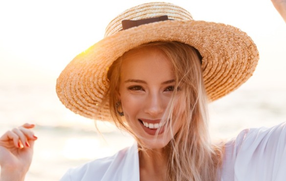 woman wearing hat on the beach | Williamson Realty