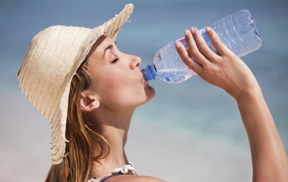 woman drinking water on the beach | Williamson Realty