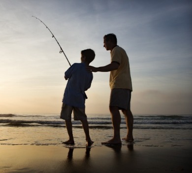father and son fishing on the beach | Williamson Realty