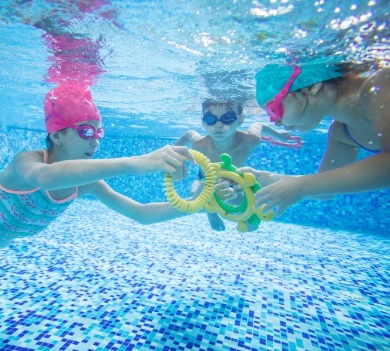 kids playing with pool toys in swimming pool | Williamson Realty