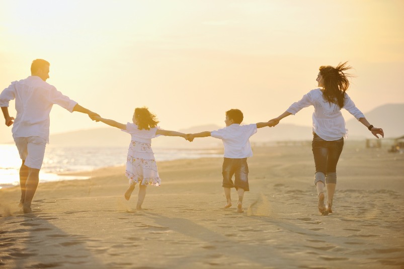 family walking on the beach | Williamson Realty