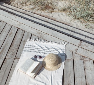 Book, sunglasses and beach blanket on boardwalk | Williamson Realty Ocean Isle Beach NC Rentals