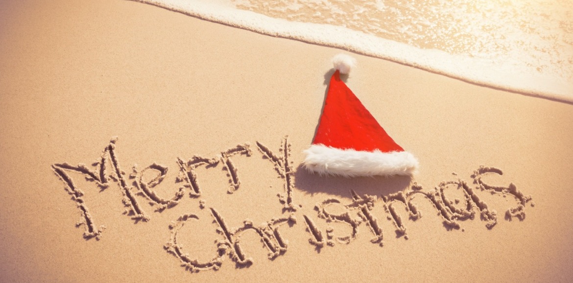 Merry Christmas written in sand with Santa Hat  | Williamson Realty