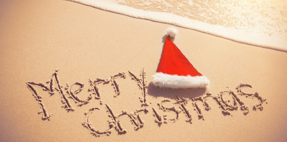 Merry Christmas written in sand with Santa Hat | Williamson Realty