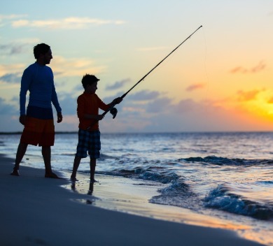 Dad fishing with son on the beach | Williamson Realty Vacations Ocean Isle Beach NC Rentals