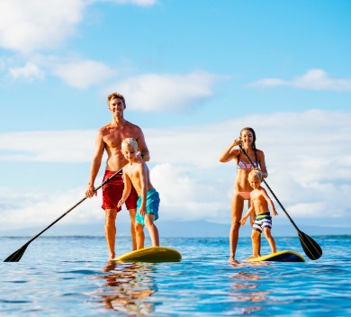 Family paddleboarding together on ocean | Williamson Realty Vacations Ocean Isle Beach NC Rentals