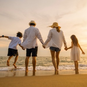 Family on the beach holding hands  | Williamson Vacations Ocean Isle Beach Rentals