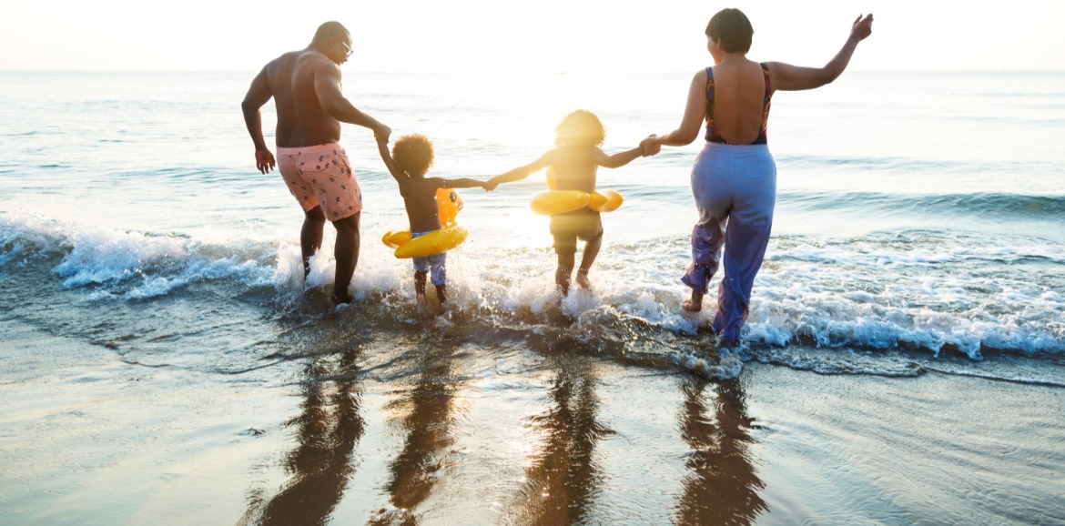Family splashing in the Atlantic Ocean waves | Williamson Realty Vacations Ocean Isle Beach Rentals