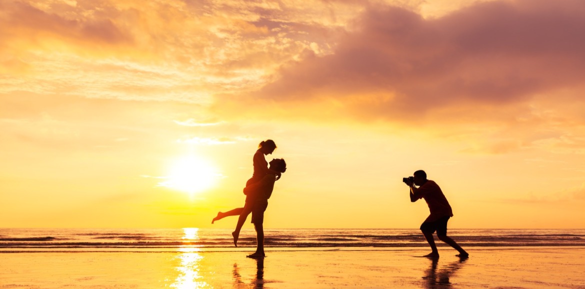 Couple getting photo taken at golden hour on the beach | Williamson Realty Vacations Ocean Isle Beach Rentals