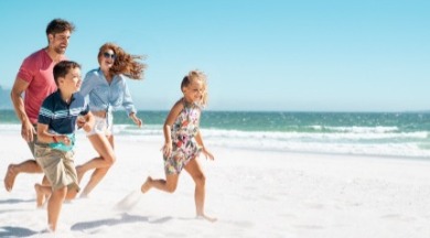 family happily running on the beach | Williamson Realty