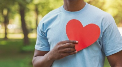 man holding paper heart over his chest | Williamson Realty