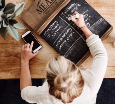 Woman writing down meals on chalkboard | Williamson Realty Vacations Ocean Isle Beach NC Rentals