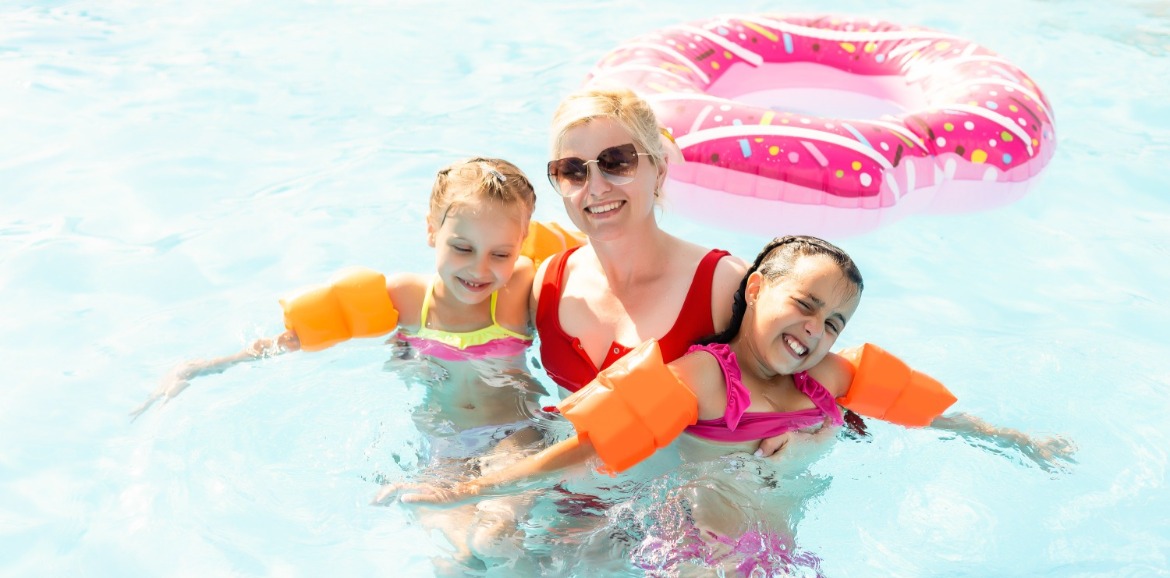 Mom and two daughters in the pool on vacation | Williamson Realty Vacations Ocean Isle Beach Rentals