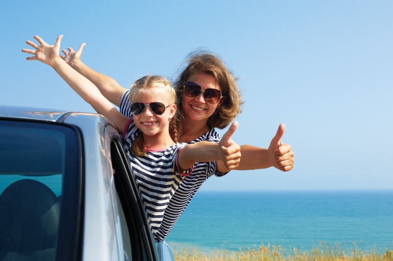 mom and daughter on beach thumbs up | Williamson Realty Vacations