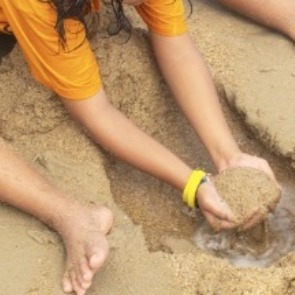 Child filling in a hole in the sand | Williamson Realty Vacation Rentals Ocean Isle Beach NC
