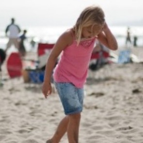 Little girl walking on busy beach | Williamson Realty Vacation Rentals Ocean Isle Beach NC