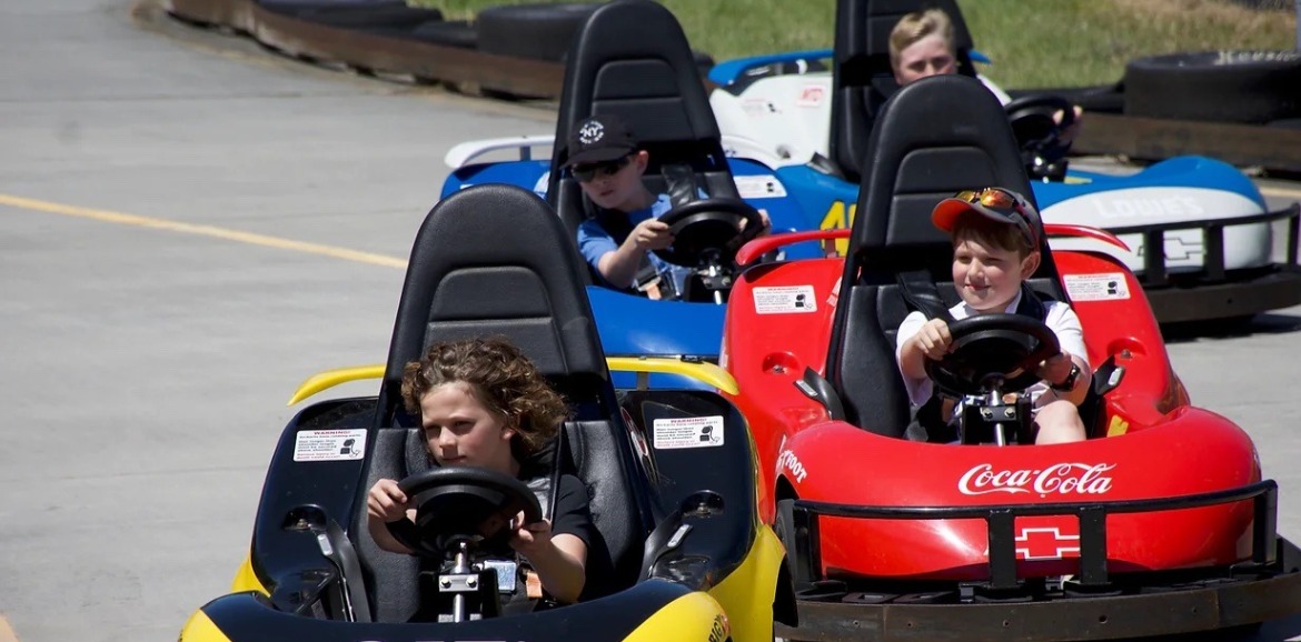 Kids racing in go-karts at the Ocean Isle Beach Super Track | Williamson Realty Vacations OIB Vacation Rentals